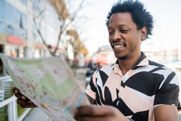 导游一幅非洲游客在街上户外散步时在地图上寻找方向的画像街道旅行者发现