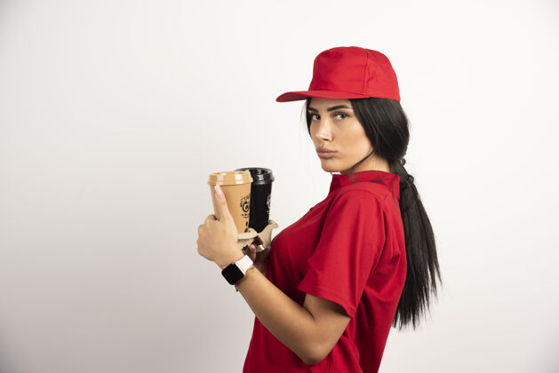 工人穿着红色制服的信使手里拿着两杯咖啡高质量的照片制服肖像咖啡