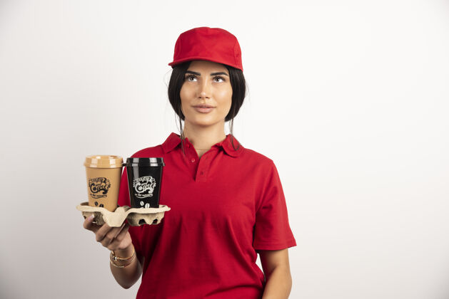 肖像带咖啡杯的送货员在白色背景上摆姿势高质量照片工人快递咖啡