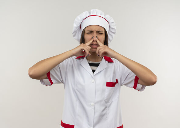 烹饪恼怒的年轻女厨师穿着厨师制服 鼻子紧闭 眼睛被隔离在白色皮肤上制服厨师眼睛