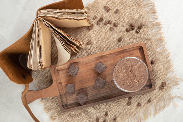 香味咖啡和巧克力块放在木板上 还有豆子和笔记本巧克力美味咖啡