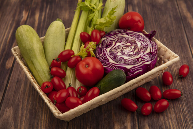 新鲜木制背景上的水桶上的健康蔬菜的顶视图 如西红柿 芹菜 紫色卷心菜和西葫芦观点卷心菜顶部