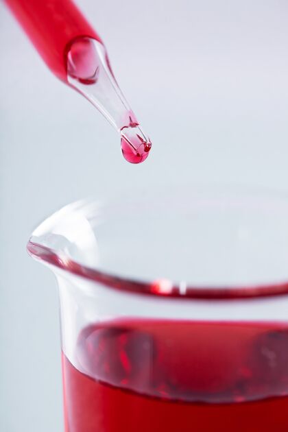 药品特写镜头上的一滴移液管和烧杯与红色液体的白色背景实验室瓶子医学