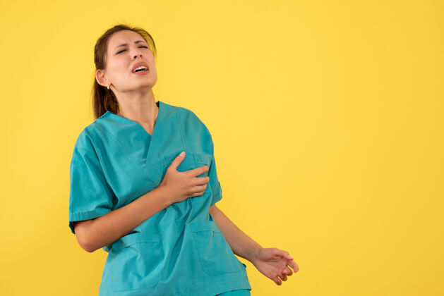 黄色正面图黄色背景上穿着医疗衬衫的女医生心痛女医生医疗健康