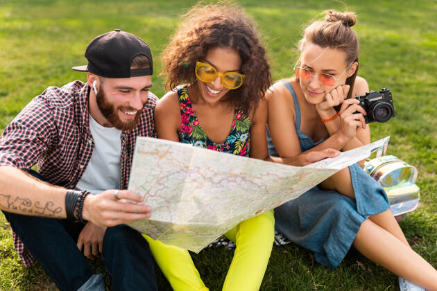 旅游快乐年轻的朋友们一起坐公园旅游 看地图观光 男女同乐女人太阳镜微笑