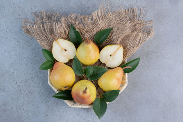 配料美味的梨和装饰性的叶子放在大理石背景的小篮子里营养美味新鲜