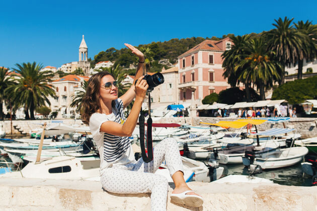女士迷人的女人在欧洲海边度假 在游轮上用相机拍照欢呼人旅游