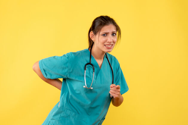 医学前视图黄色背景上穿着医用衬衫的女医生女医生观点护士
