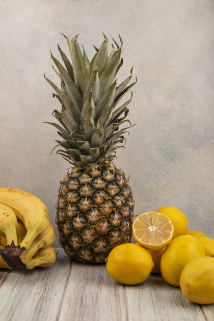 可口侧视图美味的水果 如香蕉菠萝和柠檬隔离在一个灰色的表面柠檬营养农业