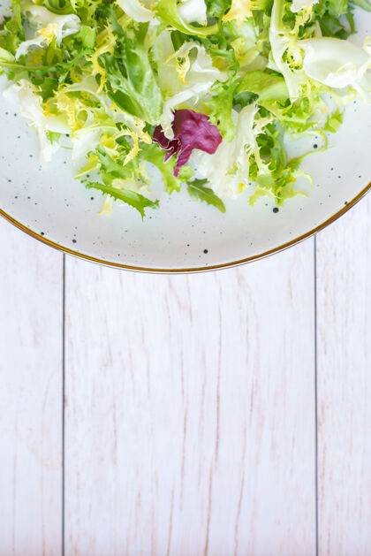 火箭白色陶瓷盘子 木质表面有新鲜沙拉营养有机午餐