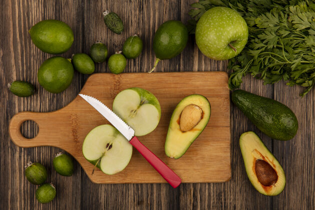 午餐新鲜的鳄梨和苹果放在木制的菜板上 刀子上夹着酸橙和鳄梨 它们被隔离在木制的表面上素食蔬菜刀