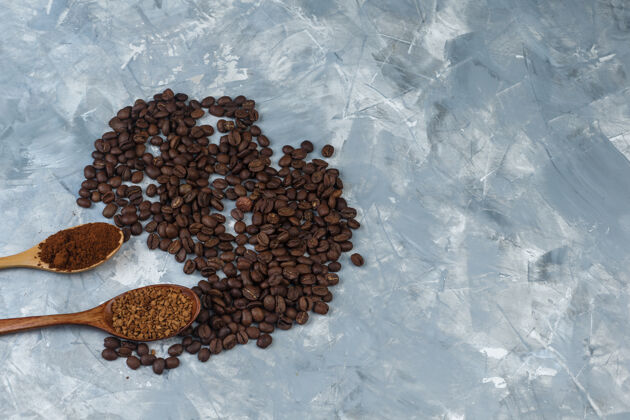 咖啡馆一套速溶咖啡和咖啡粉装在木勺里 咖啡豆放在浅蓝色大理石背景上特写杯子早餐勺子