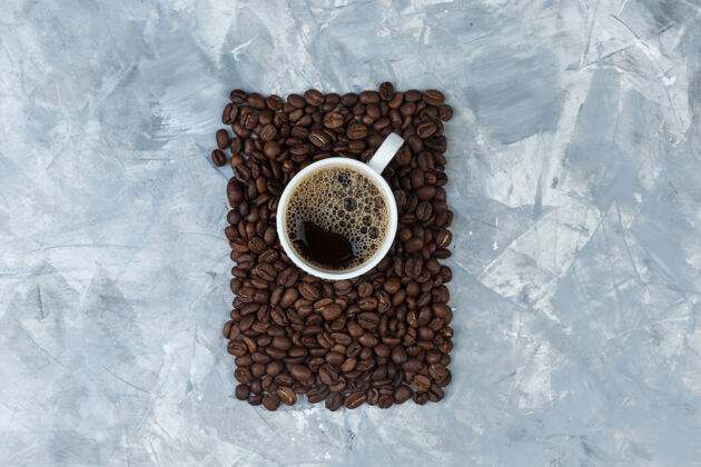 乡村的一套咖啡豆和咖啡在一个蓝色大理石背景的杯子顶视图摩卡套装马克杯