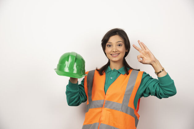 专业女工程师表现出良好的姿态 手持白色背景的头盔工人建筑工人女士