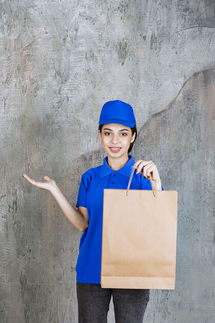 外卖穿着蓝色制服的女服务人员手里拿着一个纸板购物袋工人年轻人船运