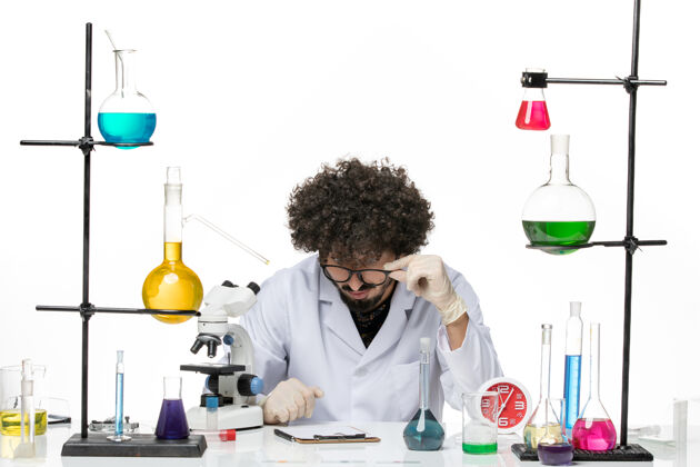 笔记正面图：穿着医疗服的男性化学家在空白处写下笔记专业羽绒男化学家