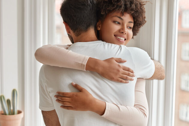 混合积极的黑皮肤妻子拥抱她的丈夫拥抱关系拍摄