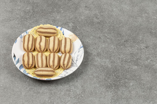 可口美味的巧克力条纹饼干放在五颜六色的盘子里脆食品饼干