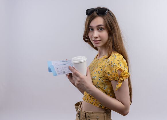 飞机年轻的旅行女孩头戴太阳镜拿着飞机票和塑料咖啡杯在隔离的白色墙上有复印空间太阳镜咖啡头