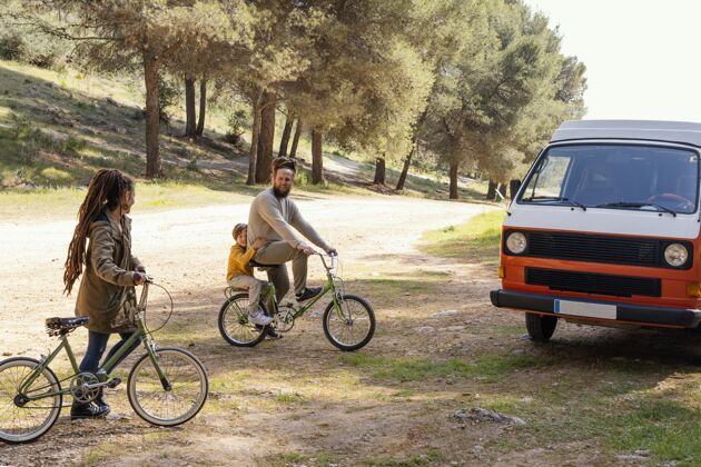 男孩在大自然中骑自行车的家庭旅行女性父母夫妇