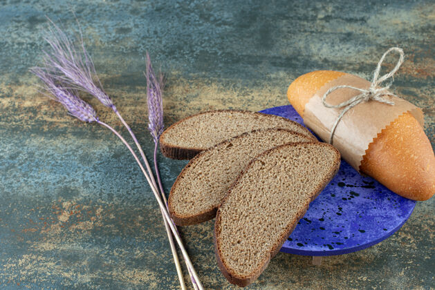 营养迷你白面包和新鲜的棕色面包片放在蓝色盘子里棕色美食食物