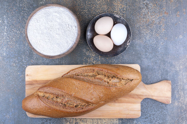 配料把面包放在面粉碗上 鸡蛋放在大理石表面指挥棒碗芝麻