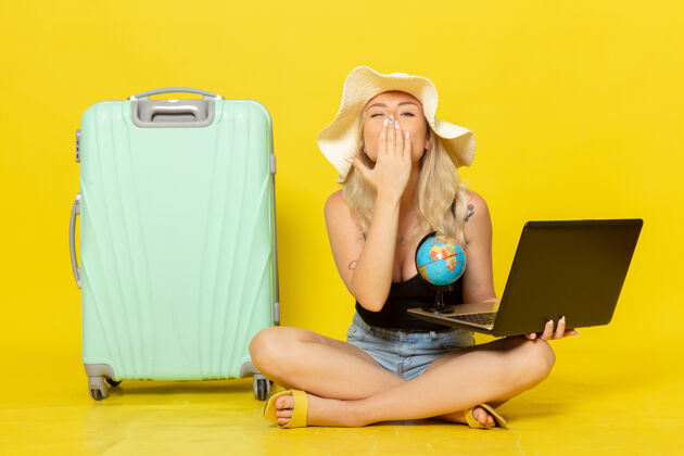 坐着正面图年轻女性手持笔记本电脑 送上飞吻前面假期旅行