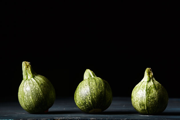 蔬菜黑墙上绿色小南瓜的特写镜头南瓜农业万圣节