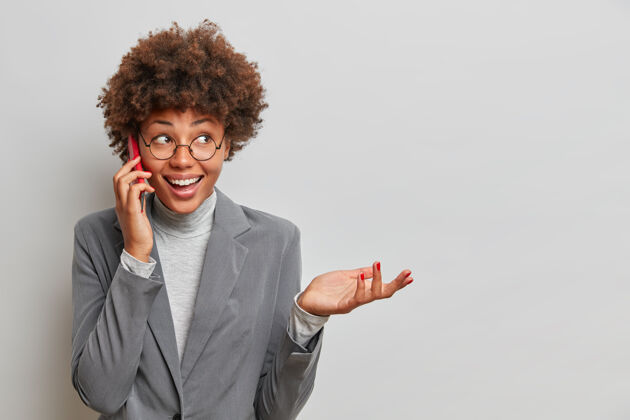 快乐快乐的美国黑人秘书通过智能手机与同事讨论工作问题 接到经理的电话 高兴地举手大笑 告知工作阶段手机民族讨论