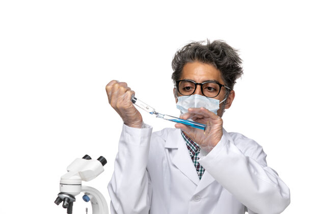 实验室外套正面图身着白色医疗服的中年科学家用蓝色溶液注射剂实验室视图医学