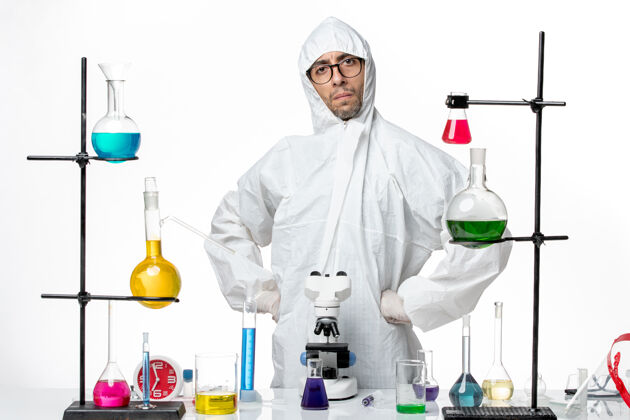 疾病正面图穿着特殊防护服的男科学家站在桌子周围 拿着解决方案科学实验室防护