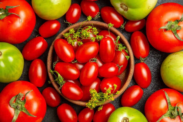 有机顶部近距离观察樱桃红色和绿色的西红柿 在黑暗的地面上放着樱桃西红柿和莳萝花番茄香草蔬菜