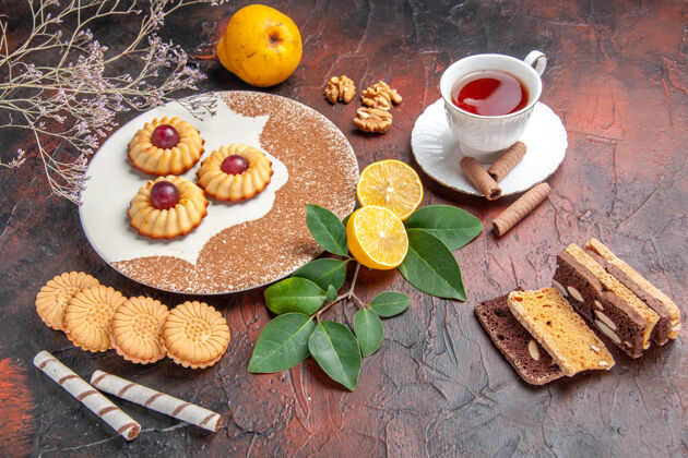 早餐俯视图美味的小饼干与一杯茶在一张深色的桌子上糖蛋糕甜饼干食物茶用餐