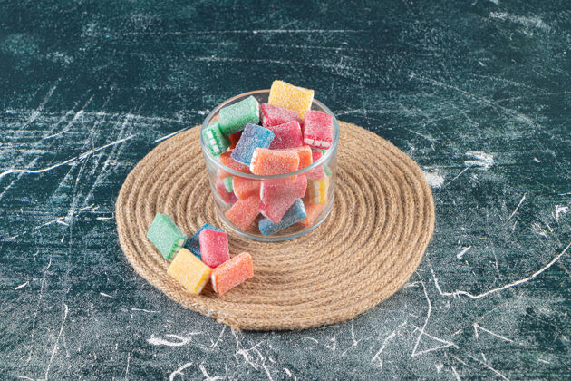 糖果五颜六色的糖果放在三角架上的玻璃碗里 放在混合桌上多彩团体美味