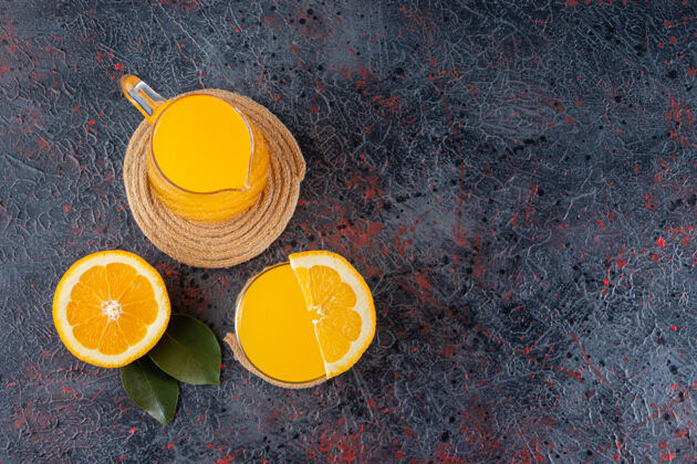 完美把鲜橙子切成薄片 放在石桌上 放上叶子和一杯果汁果味热带成熟