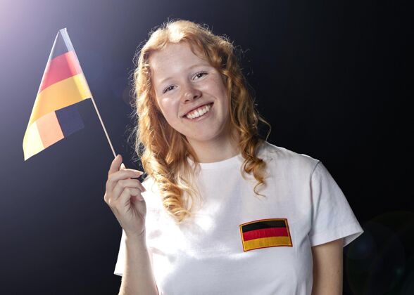 比赛举着德国国旗的笑脸女人的正视图足球联赛国旗公民