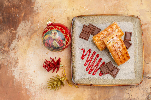 蛋糕俯瞰美味的华夫饼与巧克力条在棕色的背景容器包装饼干