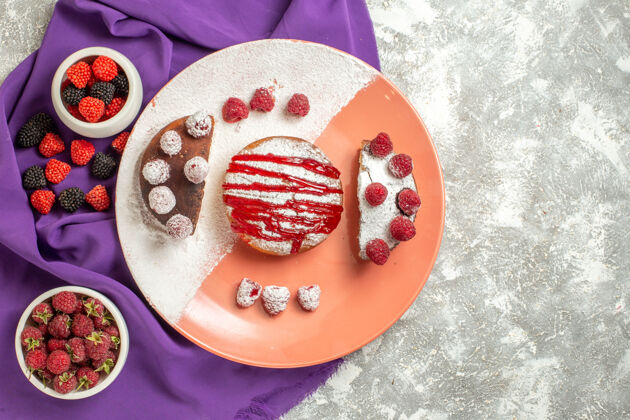 餐巾紫色餐巾上的甜点盘顶视图 大理石背景上有浆果刺绣盘子碗