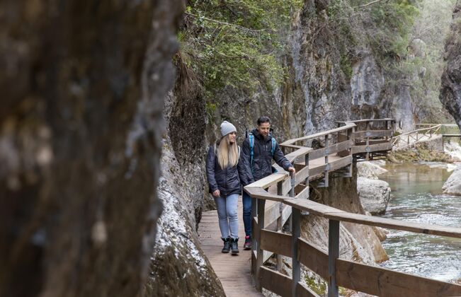 旅行一对情侣在桥上探索自然夫妇背包探索