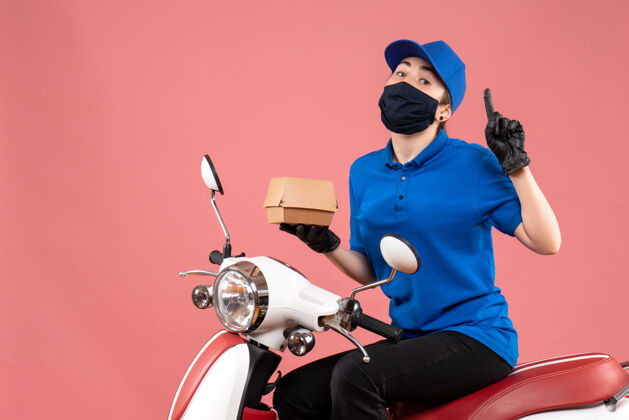 食品正面是戴着面具的女快递员 粉红色的小食品包装人制服自行车
