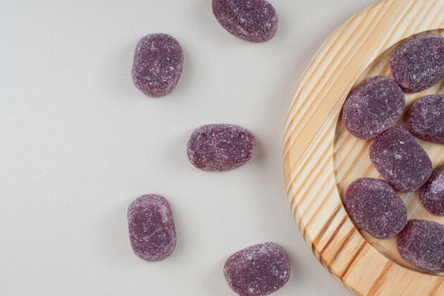 零食美味的紫色果冻糖果放在木盘上五颜六色美味糖果