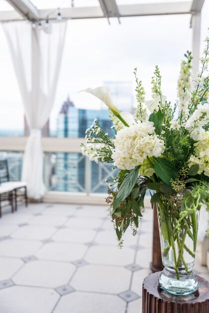 花瓶垂直特写镜头一个美丽的花束与白色的花朵在一个玻璃花瓶树叶花卉季节