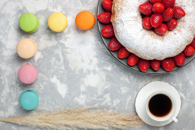 茶俯瞰美味的草莓派和茶和麦卡龙在白色蛋糕草莓杏仁饼