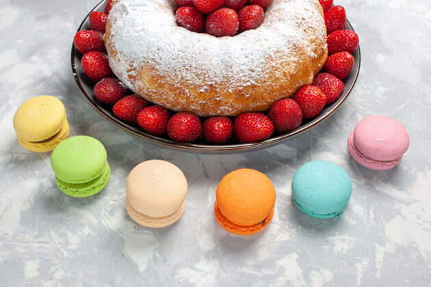 圆形前视图美味的草莓派与麦卡龙浅白色蛋糕美味盘子