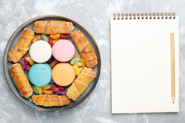 肉桂俯瞰法国马卡龙面包圈和白色记事本杏仁饼饼干笔记本