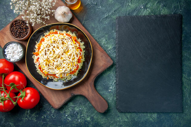 深色顶视图美味含羞草沙拉在盘子里与深蓝色背景上的红色西红柿午餐蓝色风景