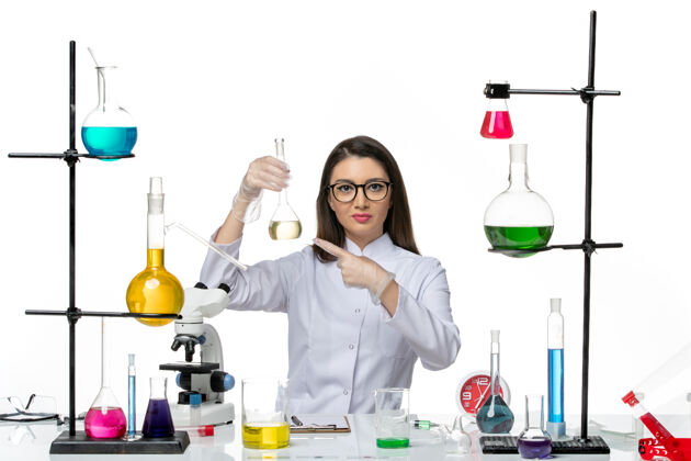 病毒前视图穿着白色医疗服的女化学家正在处理白色背景的科维科学大流行实验室病毒的解决方案正面药品医疗