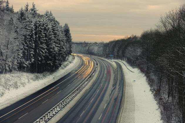 车辆黄昏时分 德国伯吉斯地区 一条高速公路在冬天的景色中被长时间曝光光速度树