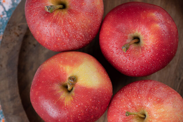 酸把苹果孤立在一个朴素的木盘上水果艺术食物