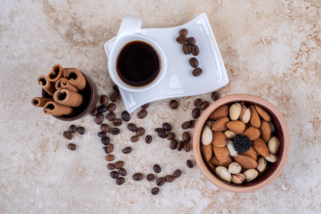 肉桂散落的咖啡豆 各种坚果 肉桂条和一杯咖啡坚果杯子干的